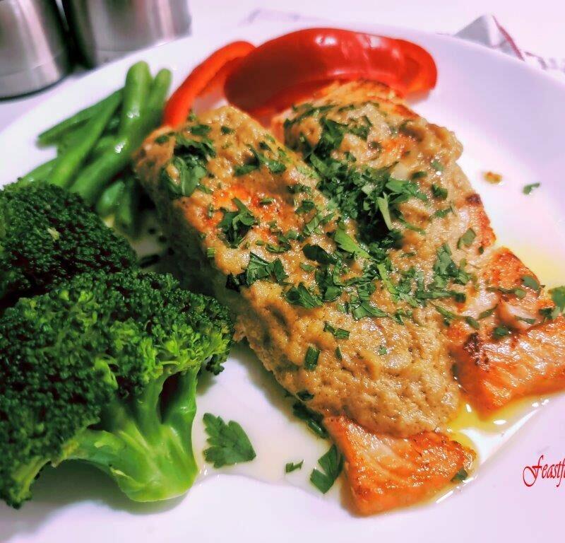 Creamy salmon slices with herb toppings and blanched broccoli