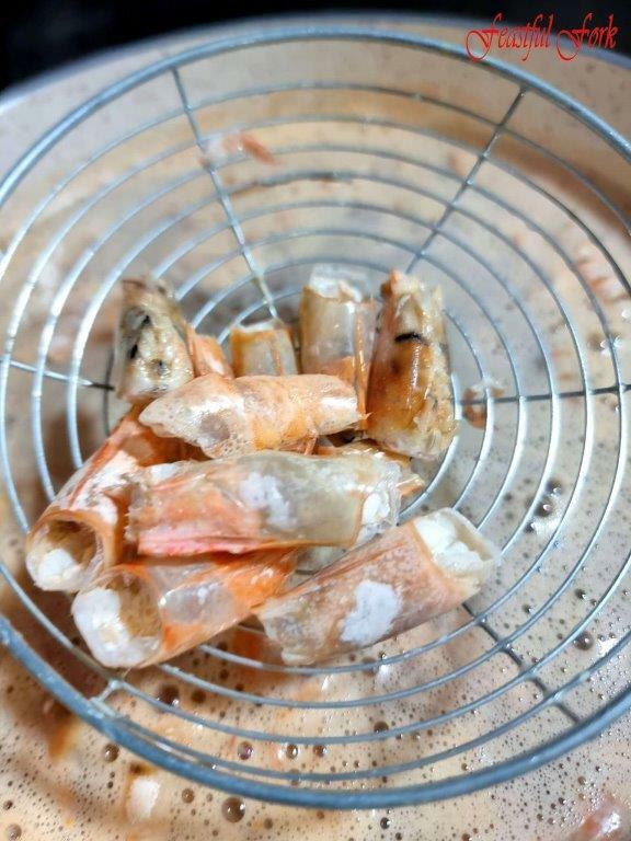 Removing shrimp heads from tom Yang soup base