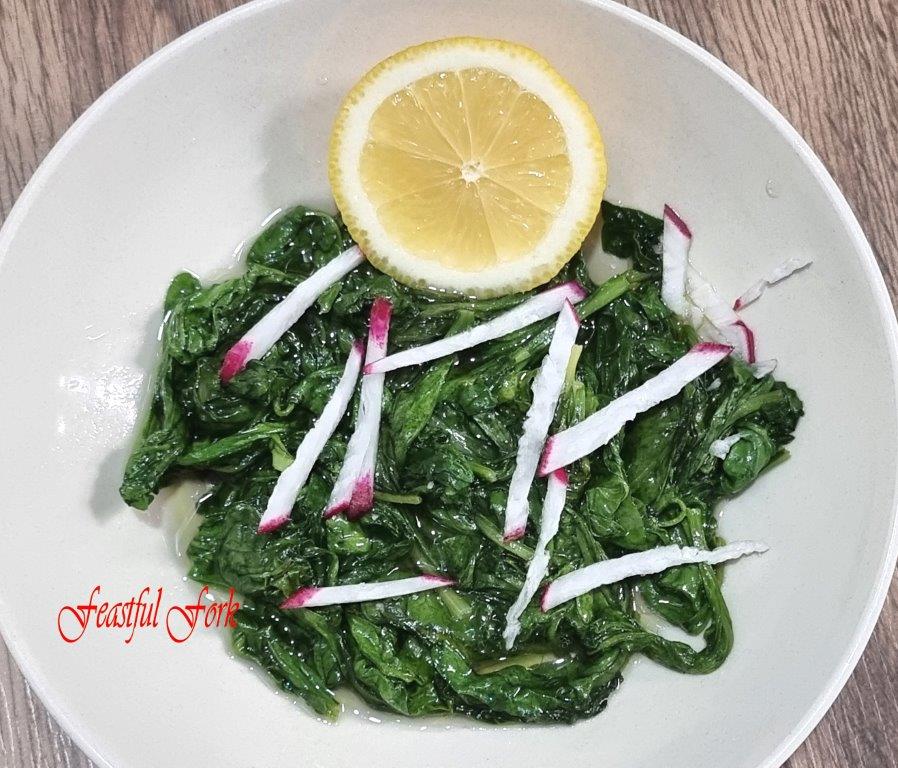 Sauteed Radish Leaves on a Plate with a Slice of Lemon